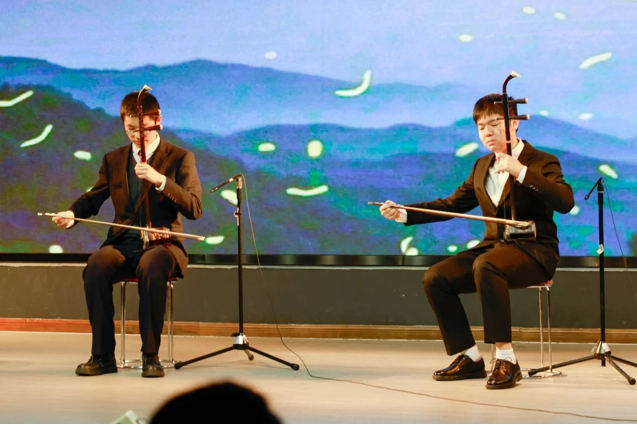 Two musicians playing erhu on stage